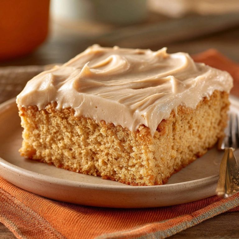 Golden spice cake, a close-up of a single frosted slice showcasing its moist crumb and creamy topping.