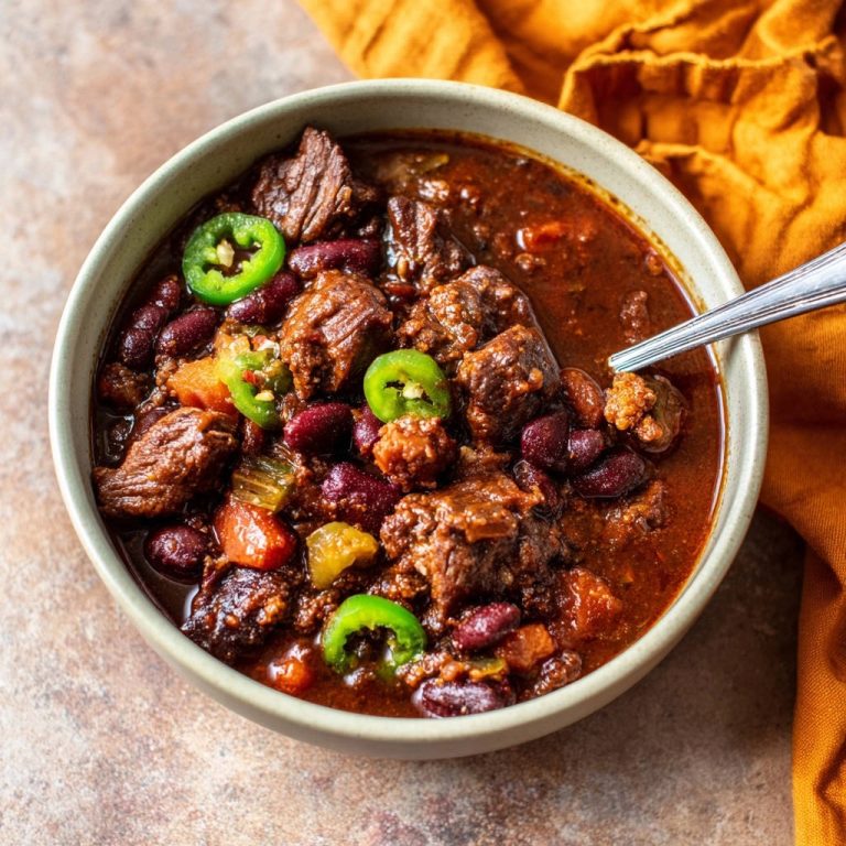 Hearty beef & bean chili in a bowl, showcasing tender chunks of beef, kidney beans, and jalapeño slices.