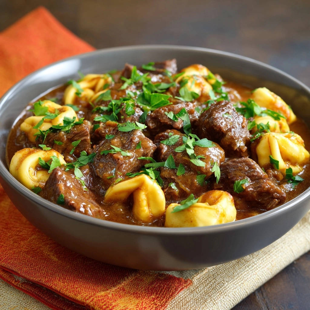 Hearty Beef & Tortellini Stew with tender chunks of beef and pasta, garnished with fresh parsley.