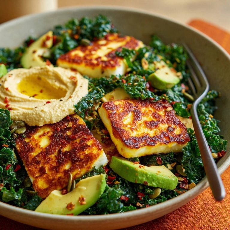 Pan-seared halloumi kale bowl with a close-up view of golden-brown halloumi cheese and creamy hummus.