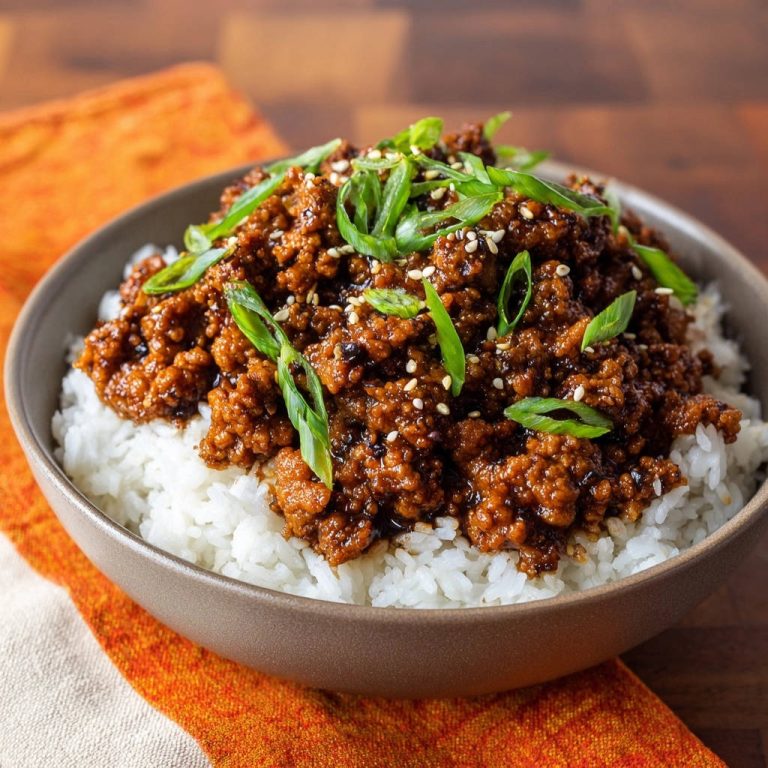 Quick ground beef bowls served over white rice, generously garnished with fresh green scallions and sesame seeds.