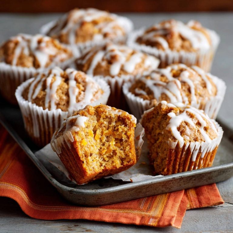 Amazing glazed carrot muffins shown in a close-up cross-section revealing their moist, textured interior.