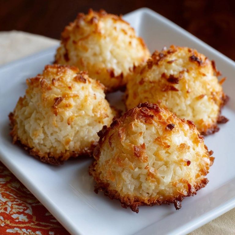 Perfect coconut macaroons with chewy centers shown on a white plate with golden-brown toasted tops.