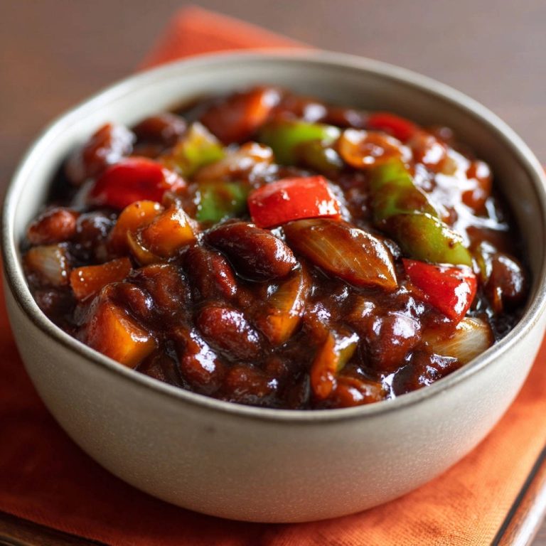 Hearty vegetarian chili in a close-up bowl with visible beans and vegetables in a rich sauce.