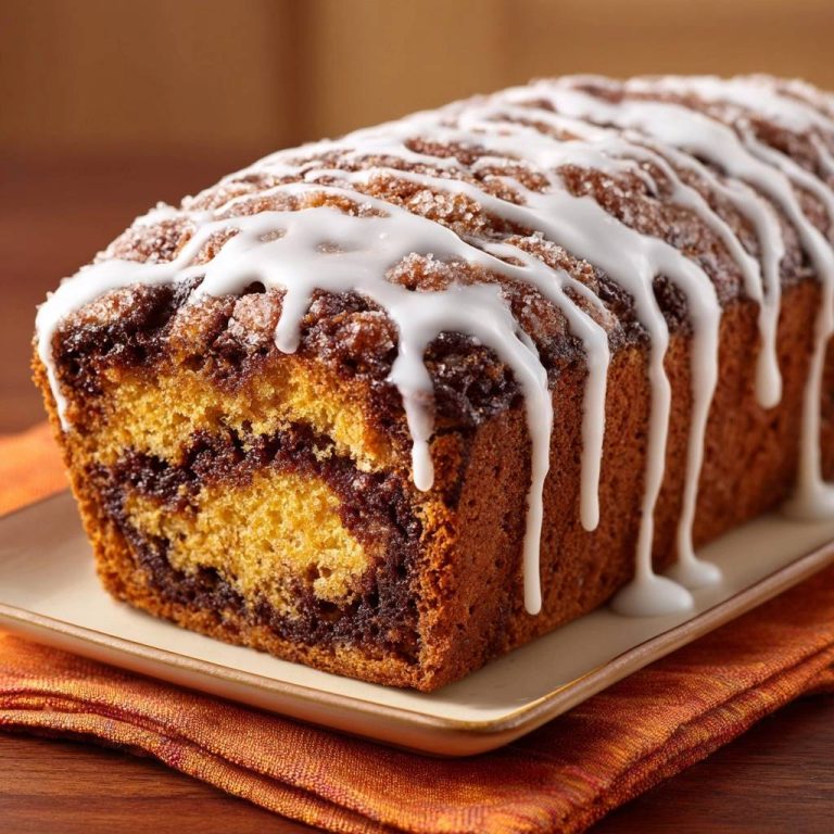 Pumpkin cinnamon swirl bread recipe shown in a close-up cross-section, highlighting the rich cinnamon swirls within the moist bread.