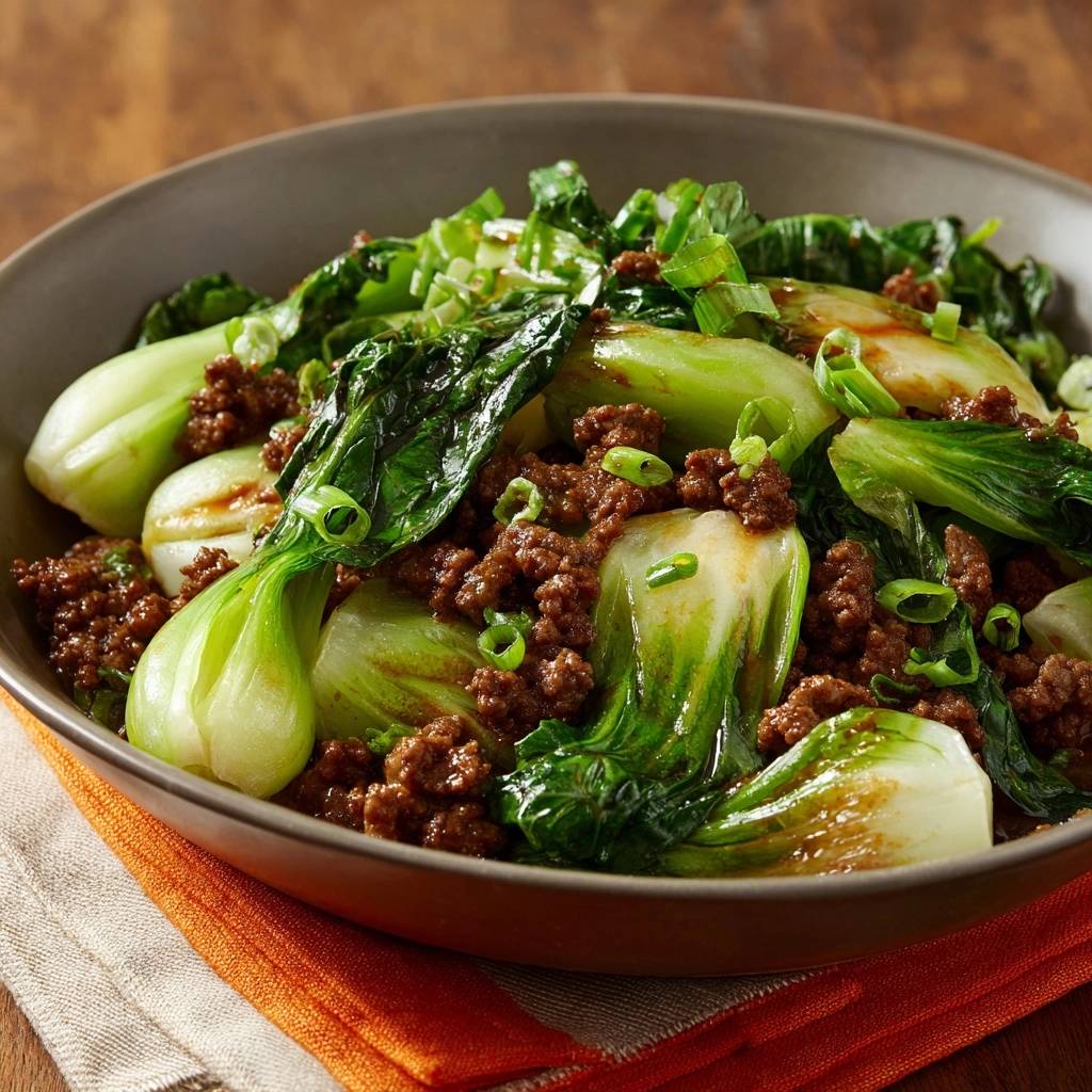 Beef and bok choy stir-fry served in a bowl, showing a close-up view of the ingredients and a glossy sauce.