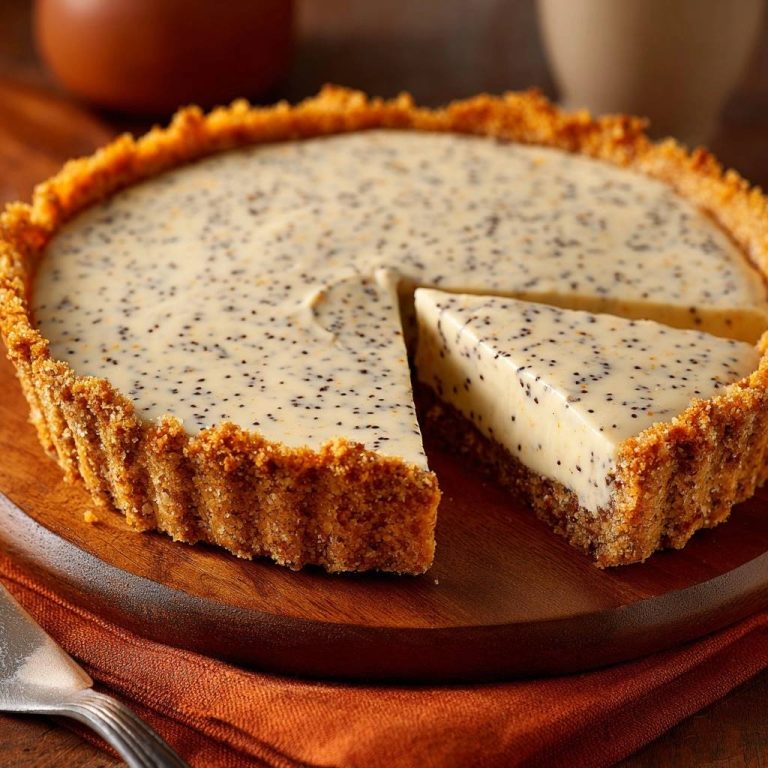 Lemon poppy seed cheesecake with a slice removed, showing its creamy filling and textured crust.