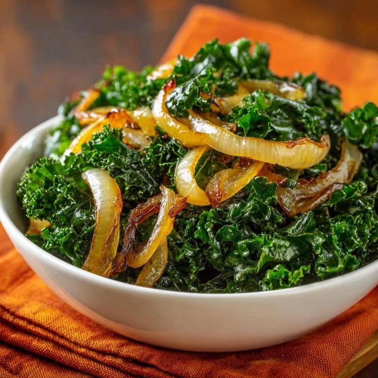 Sauteed kale with caramelized onions served in a white bowl, presented as a close-up view.