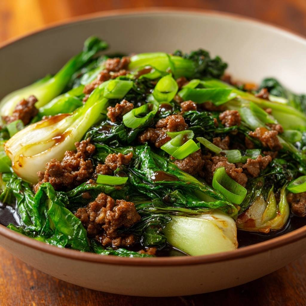 Beef Bok Choy Stir-Fry served in a bowl, featuring tender ground beef, crisp greens, and a glossy sauce with chopped scallions.