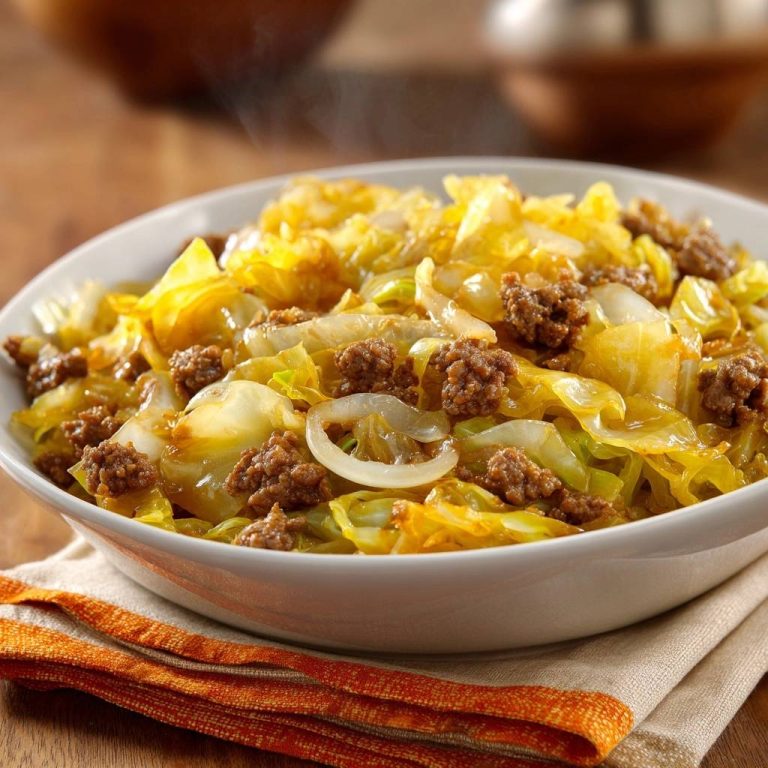 Ground Beef Cabbage Skillet served steaming in a white bowl with a textured orange napkin.