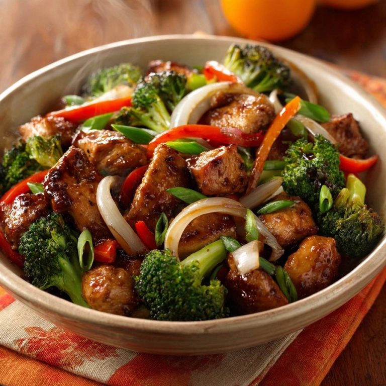 Orange chicken stir-fry with broccoli, red peppers, and onions served in a rustic bowl, a close-up view.