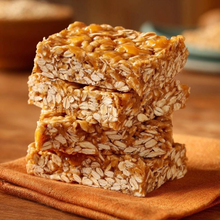 Peanut butter oat bars stacked in a close-up view, showcasing their chewy texture and glossy caramel topping.