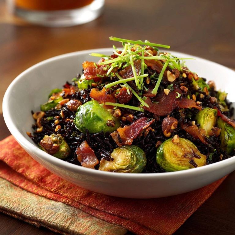 Crispy bacon Brussels black rice bowl shown in a close-up view of a white bowl filled with the dish.